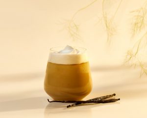 glass of vanilla latte with cream on top