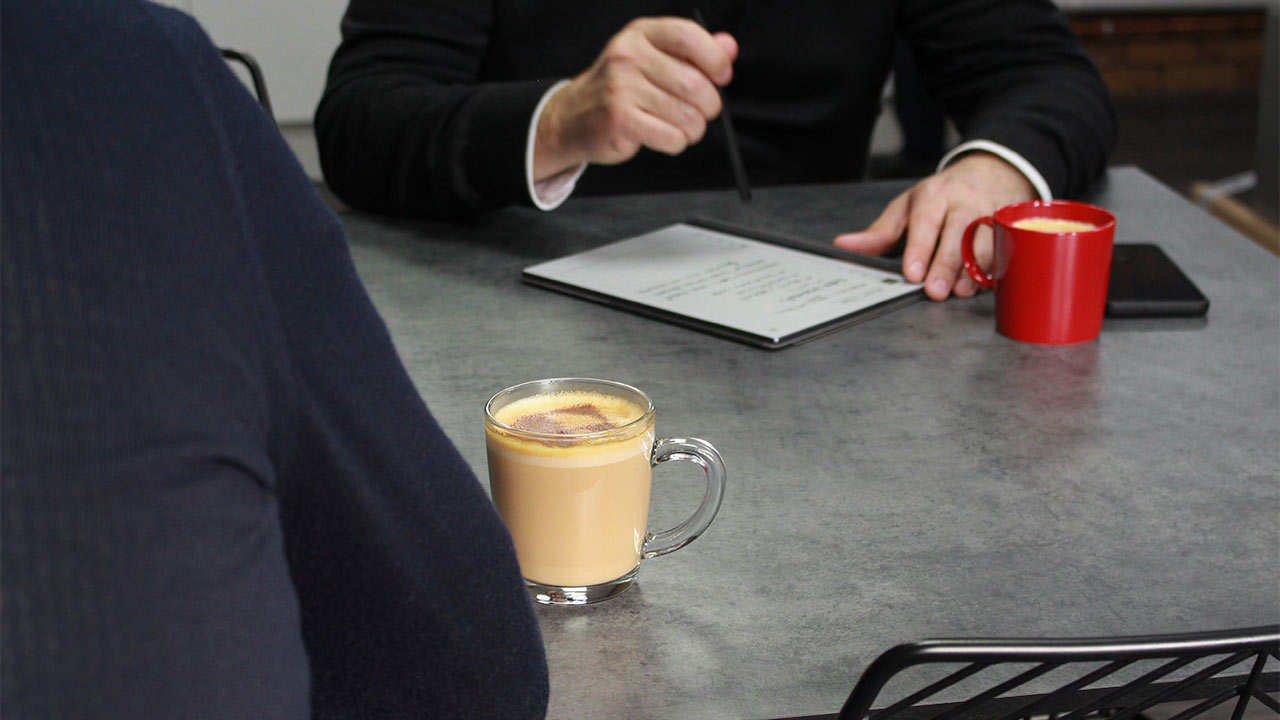 two male workers in a meeting with coffee