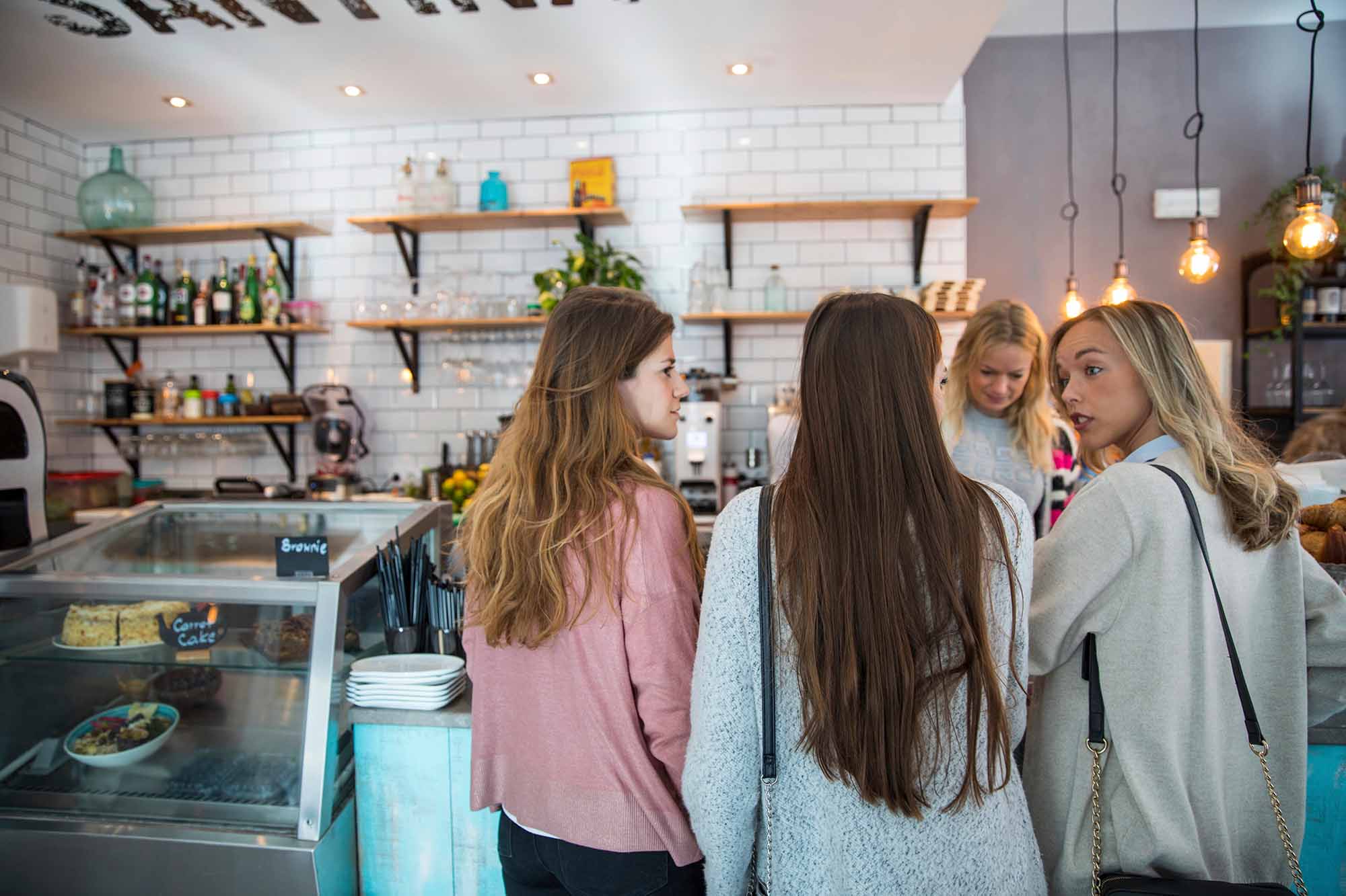 women queing for coffee in a coffee shop on their break from work